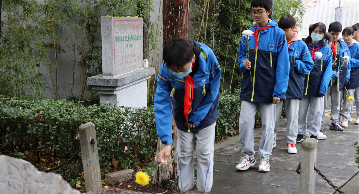 學(xué)生們?cè)谇秩A日軍南京大屠殺遇難同胞五臺(tái)山叢葬地紀(jì)念碑前獻(xiàn)花。